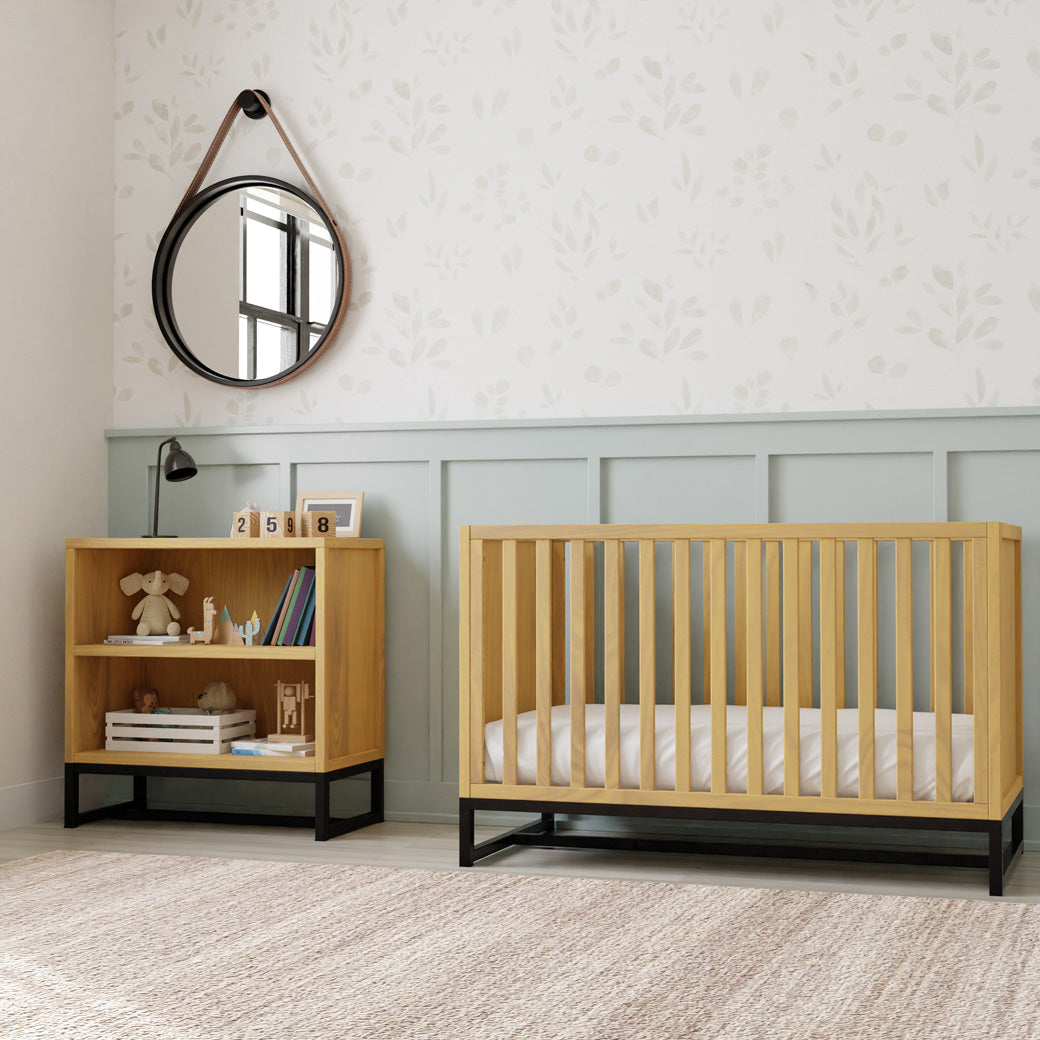 DaVinci's Ryder Convertible Cubby Changer & Bookcase next to a crib in -- Color_Honey