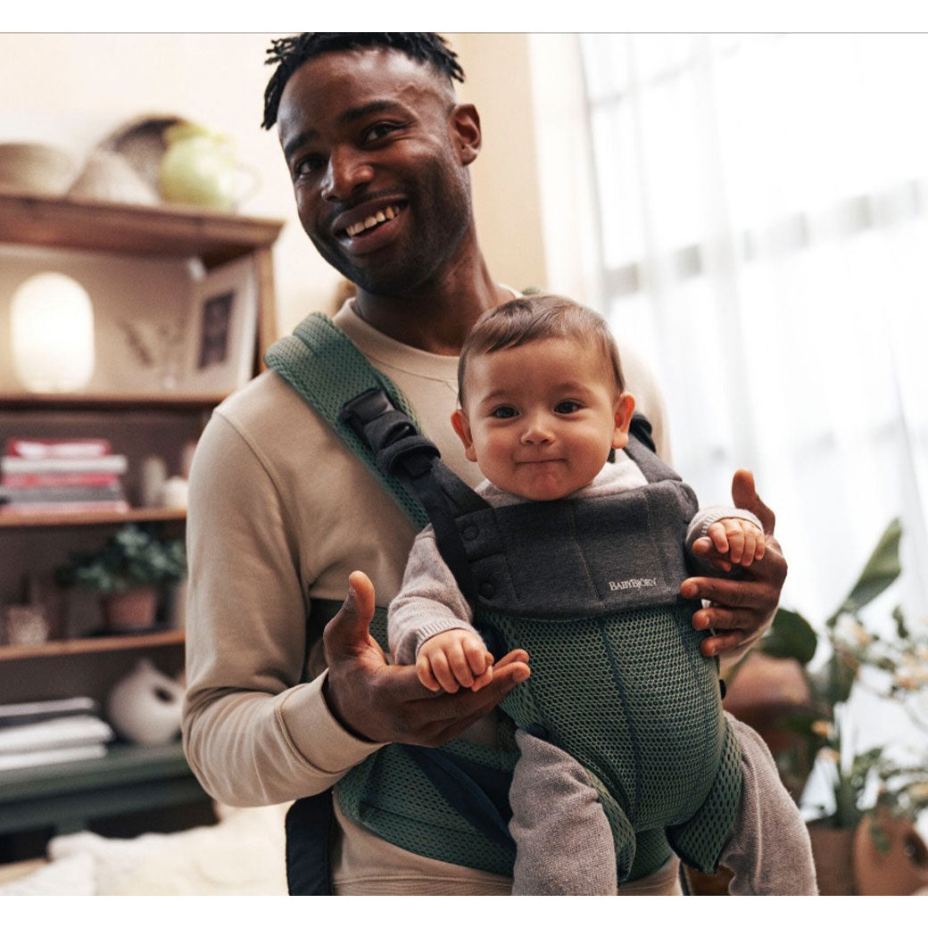 Dad smiling and carrying baby in Babybjorn Baby Carrier Harmony in -- Color_Dark Green