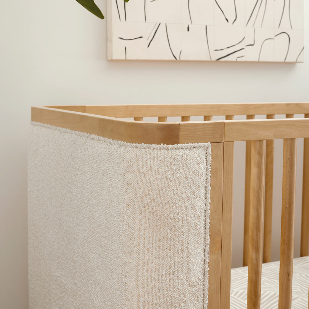 Closeup detail of Babyletto Bondi Boucle 4-in-1 Convertible Crib under a painting in -- Color_Honey with Ivory Boucle
