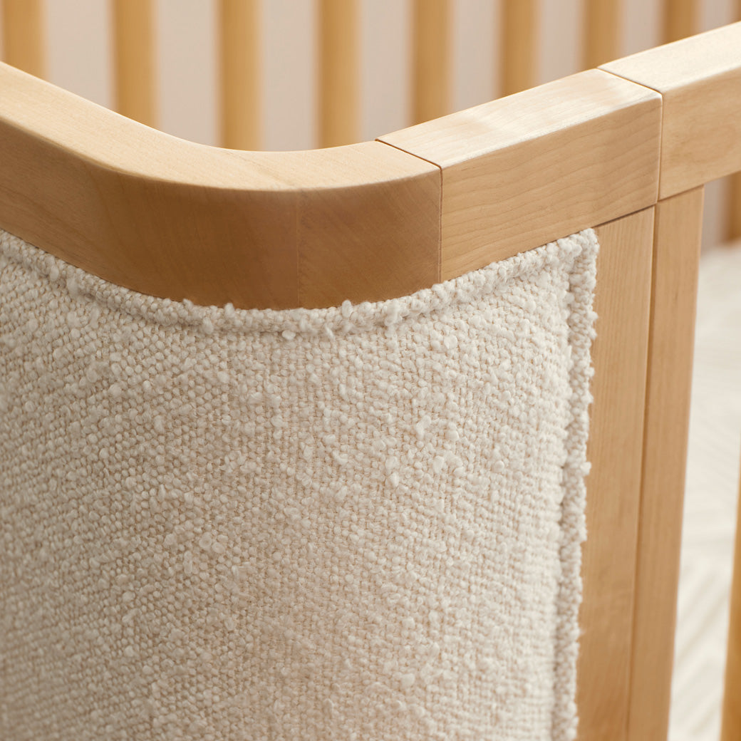 Closeup of the Babyletto Bondi Boucle 4-in-1 Convertible Crib rail in -- Color_Honey with Ivory Boucle