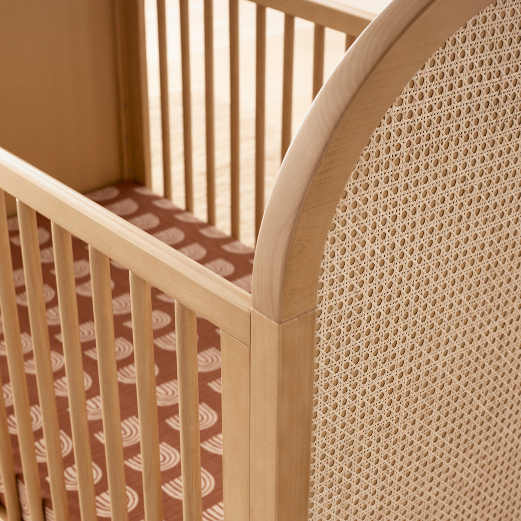 Closeup view of Babyletto Bondi Cane 3-in-1 Convertible Crib in -- Color_Honey with Natural Cane
