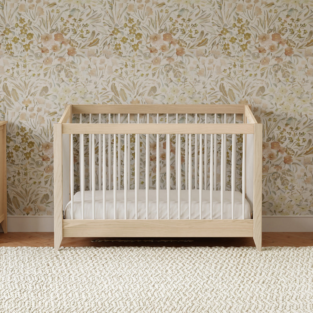 Front view of Babyletto's Sprout 4-in-1 Convertible Crib in a floral room in -- Color_Washed Natural / White