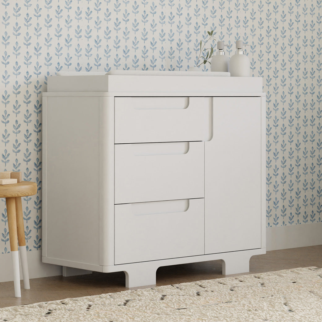 Babyletto Yuzu 3-Drawer Changer Dresser  with a changing tray and products on top in -- Color_White