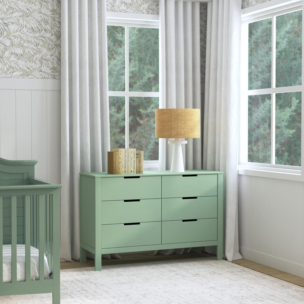 Carter's by DaVinci Colby 6-Drawer Dresser next to a crib and window  in -- Color_Light Sage