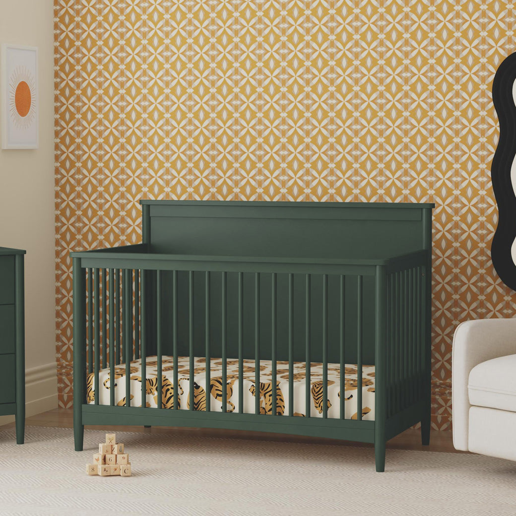 DaVinci Frem 4-in-1 Convertible Crib next to dresser and recliner  in -- Color_Forest Green