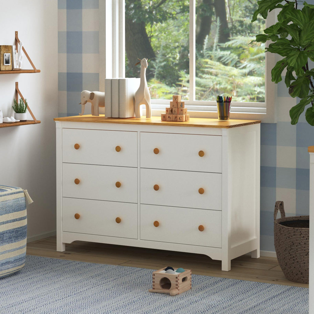 DaVinci Shea 6-Drawer Dresser under a window and with items on top  in -- Color_Warm White/Honey