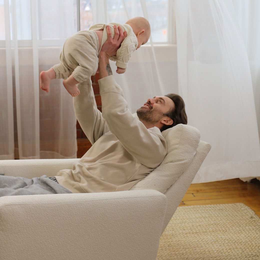 Dad holding baby in Monte Matera Glider Recliner in -- Lifestyle