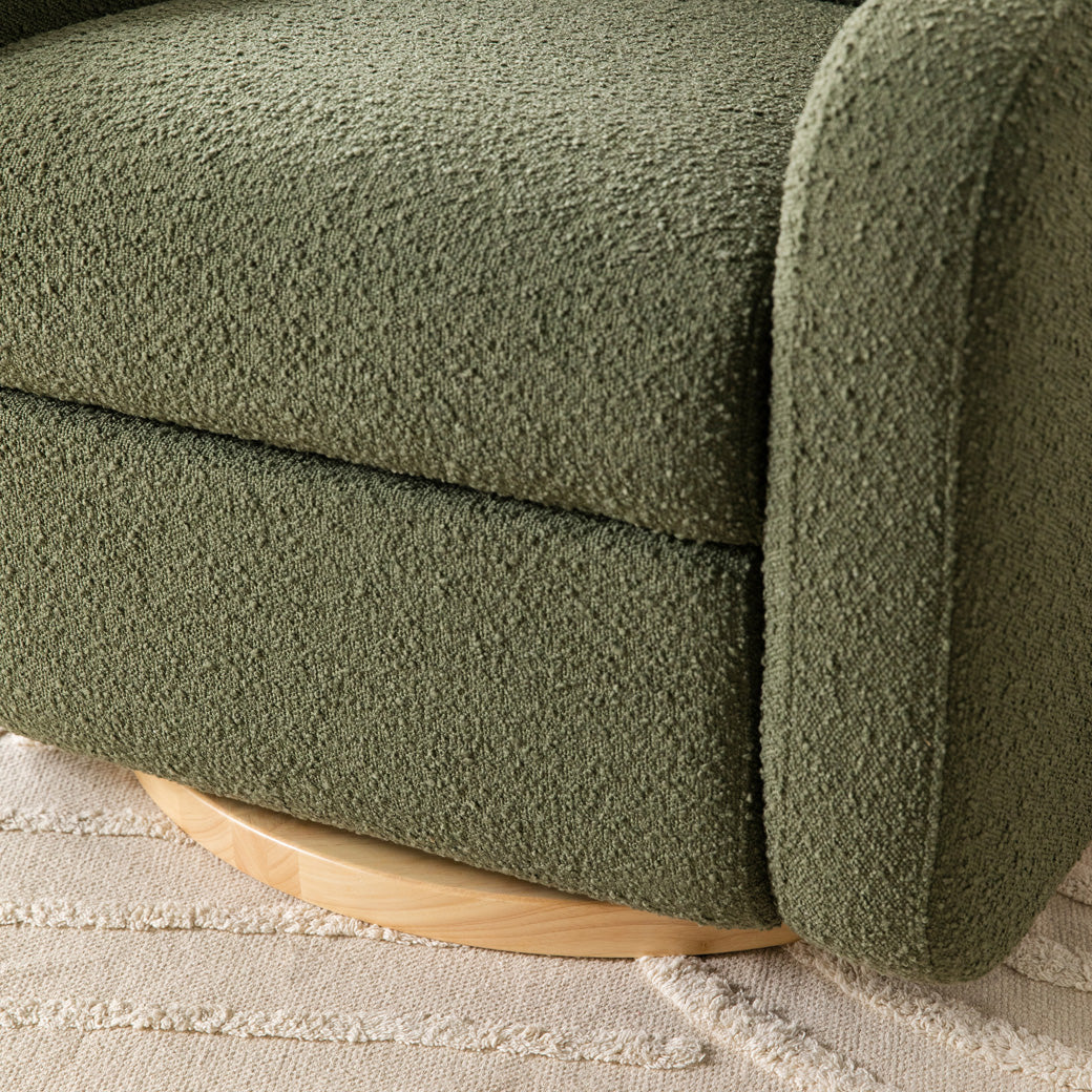 Closeup of the lower part of the The Babyletto Nami Glider Recliner in -- Color_Olive Boucle with Light Wood Base