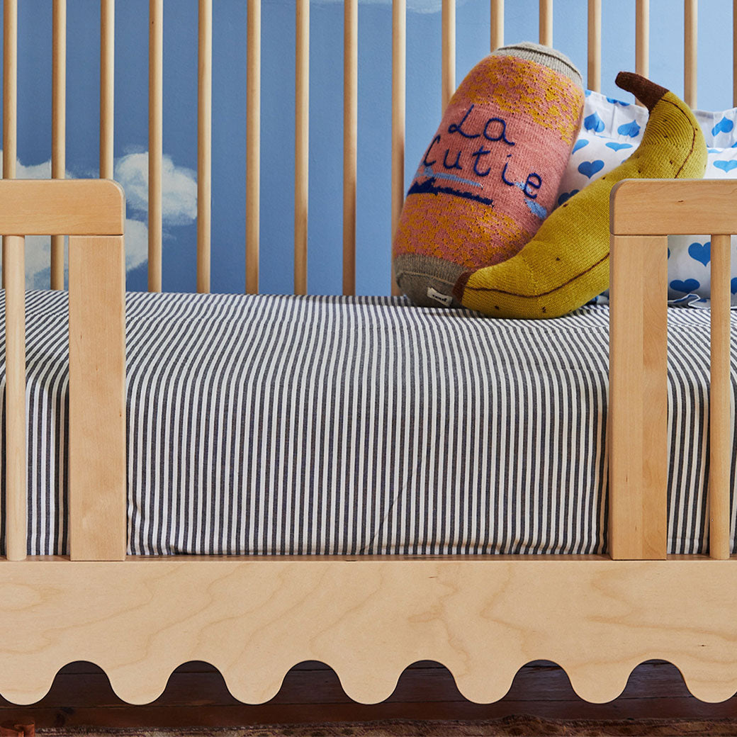 Closeup of toddler bed converted with the Oeuf Moss Conversion Kit with toys in it  in -- Lifestyle
