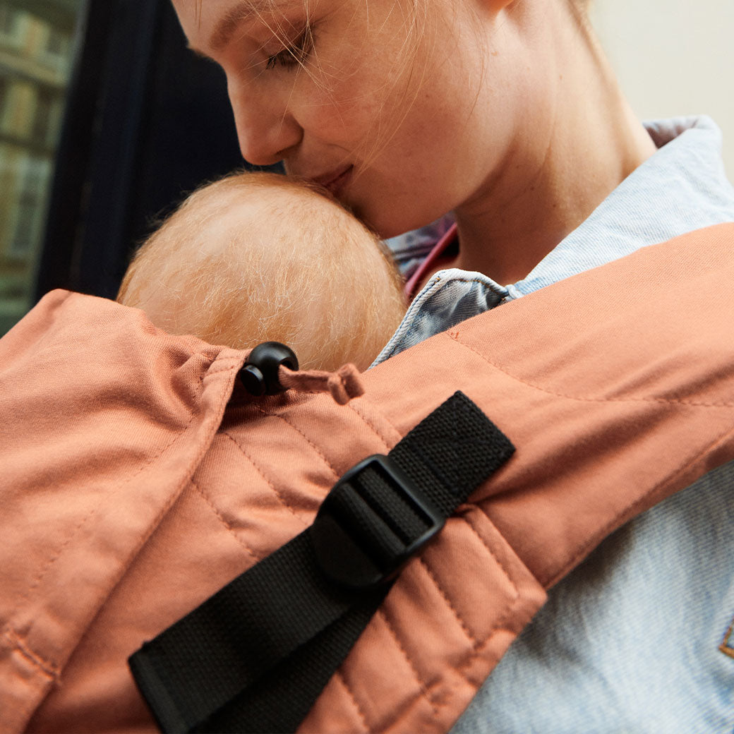 Mom kissing baby in Stokke Limas Carrier Flex in -- Lifestyle