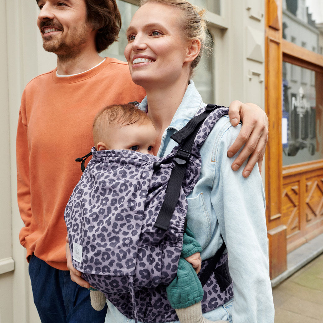 Mom and dad walking with baby in Stokke Limas Carrier Flex in -- Lifestyle