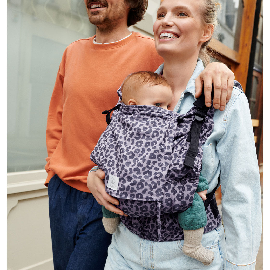 Mom and dad laughing and walking with baby in Stokke Limas Carrier Flex in -- Lifestyle
