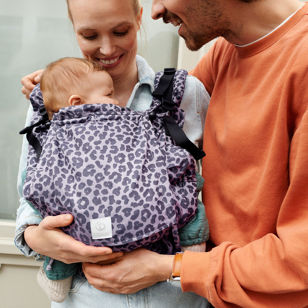 Mom holding baby in Stokke Limas Carrier Flex and dad next to them  in -- Lifestyle