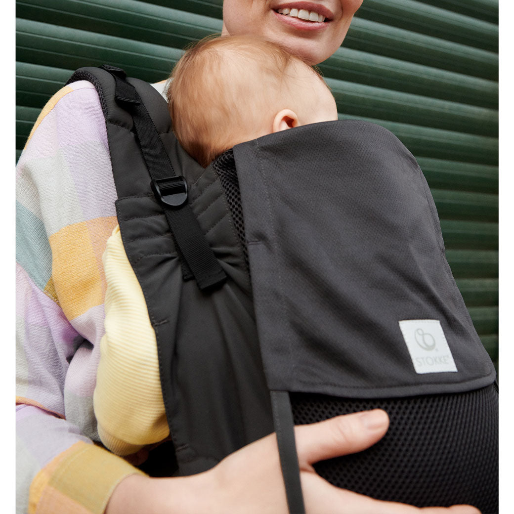 Mom carrying baby in Stokke Limas Carrier Flex in -- Lifestyle