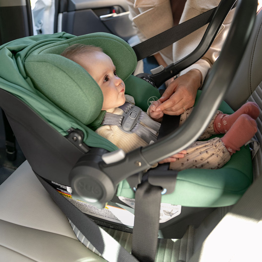Baby sitting in the Uppababy Aria Infant Car Seat in -- Color_Gwen
