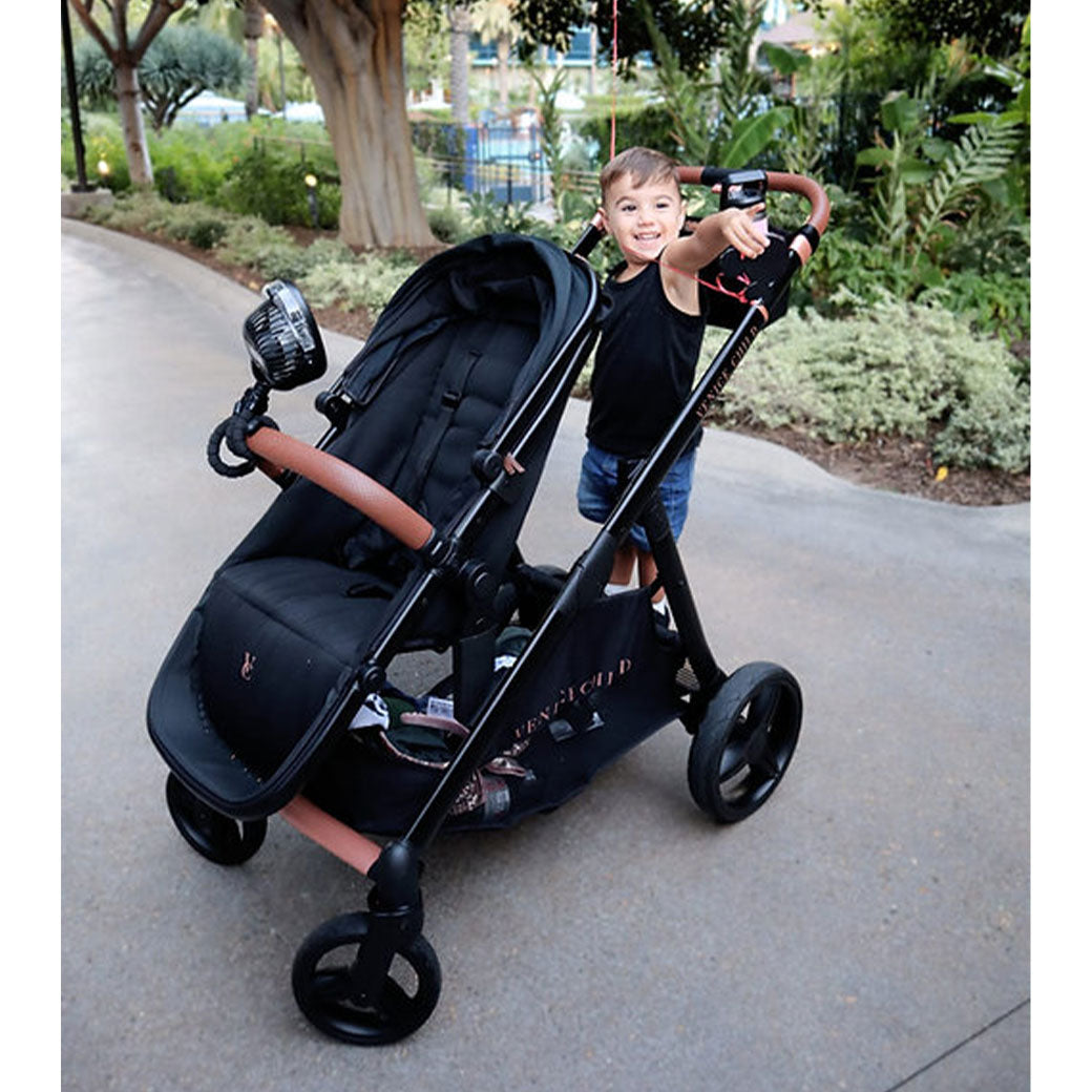 Toddler standing on the Venice Child Ventura Single to Double Sit-and-Stand Stroller & 2nd Toddler Seat in -- Color_Midnight