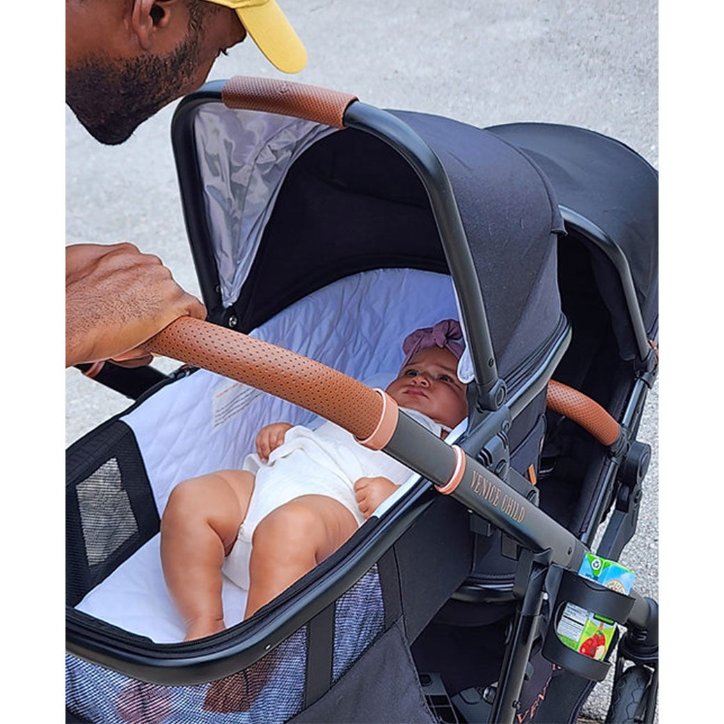 Baby laying in the Venice Child Ventura Single to Double Sit-and-Stand Stroller & Bassinet in -- Lifestyle
