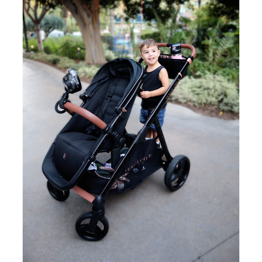 Toddler standing on the Venice Child Ventura Single to Double Sit-and-Stand Stroller & Bassinet in -- Lifestyle