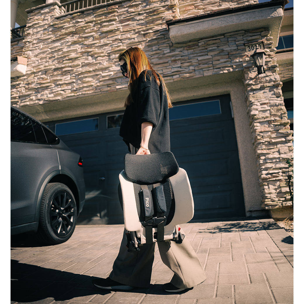 Woman in front of house holding the WAYB Pico Car Seat in -- Color_Stardust