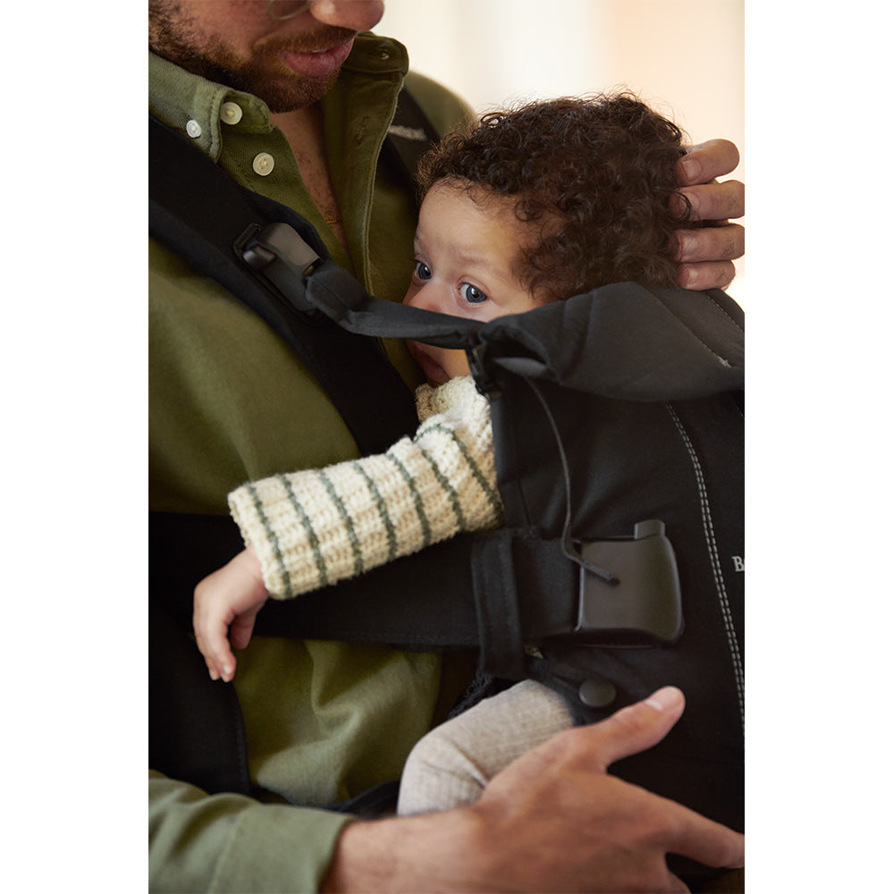 Dad holding child that is awake in the BABYBJÖRN Baby Carrier One in -- Color_Black Woven Mix