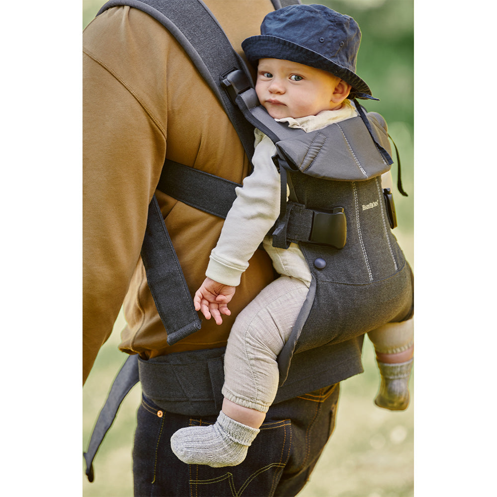 Dad walking with baby on back in the BABYBJÖRN Baby Carrier One in -- Color_Denim Gray/Dark Gray Woven Mix