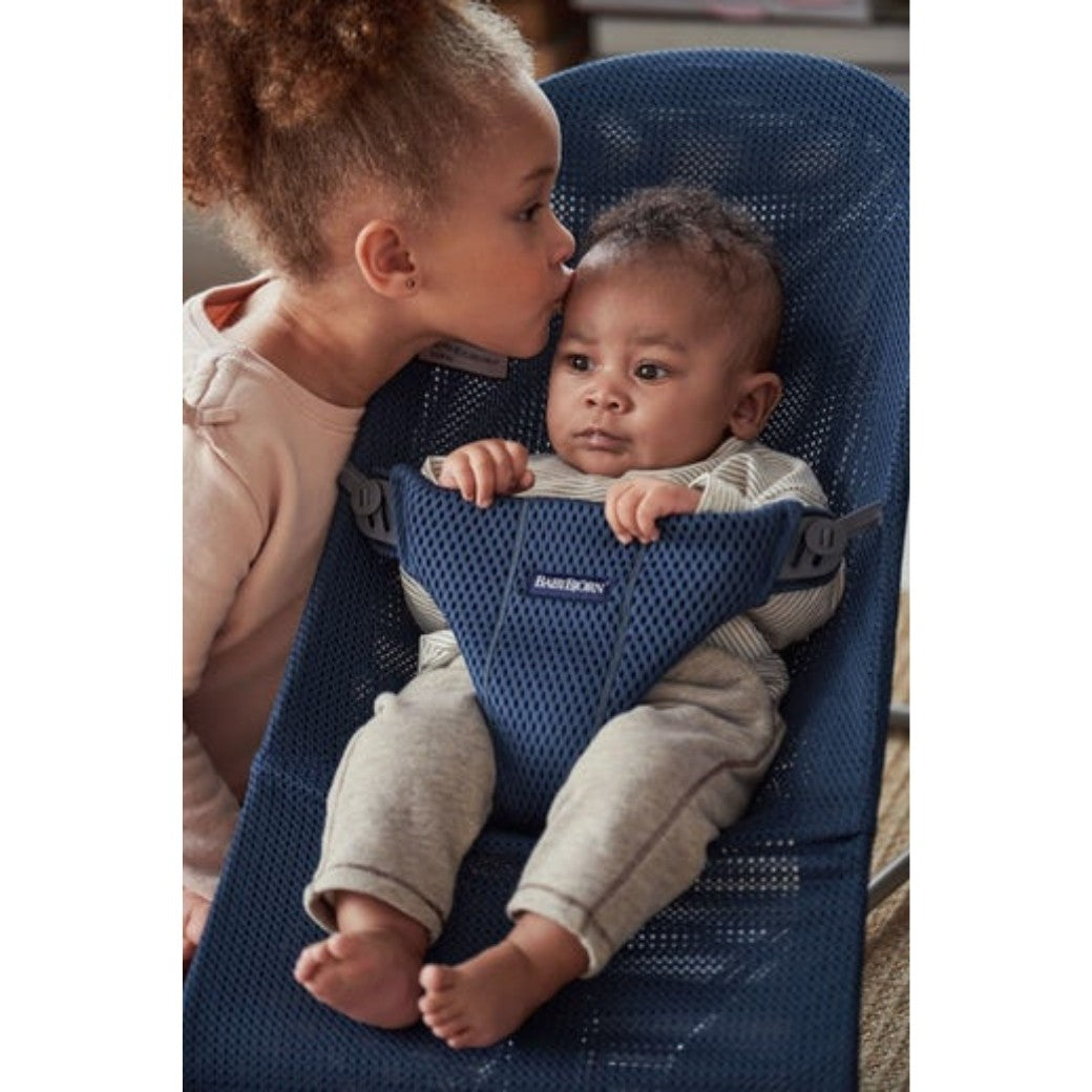 Sister kissing baby in BABYBJÖRN Bouncer Bliss in -- Color_Navy Blue Mesh