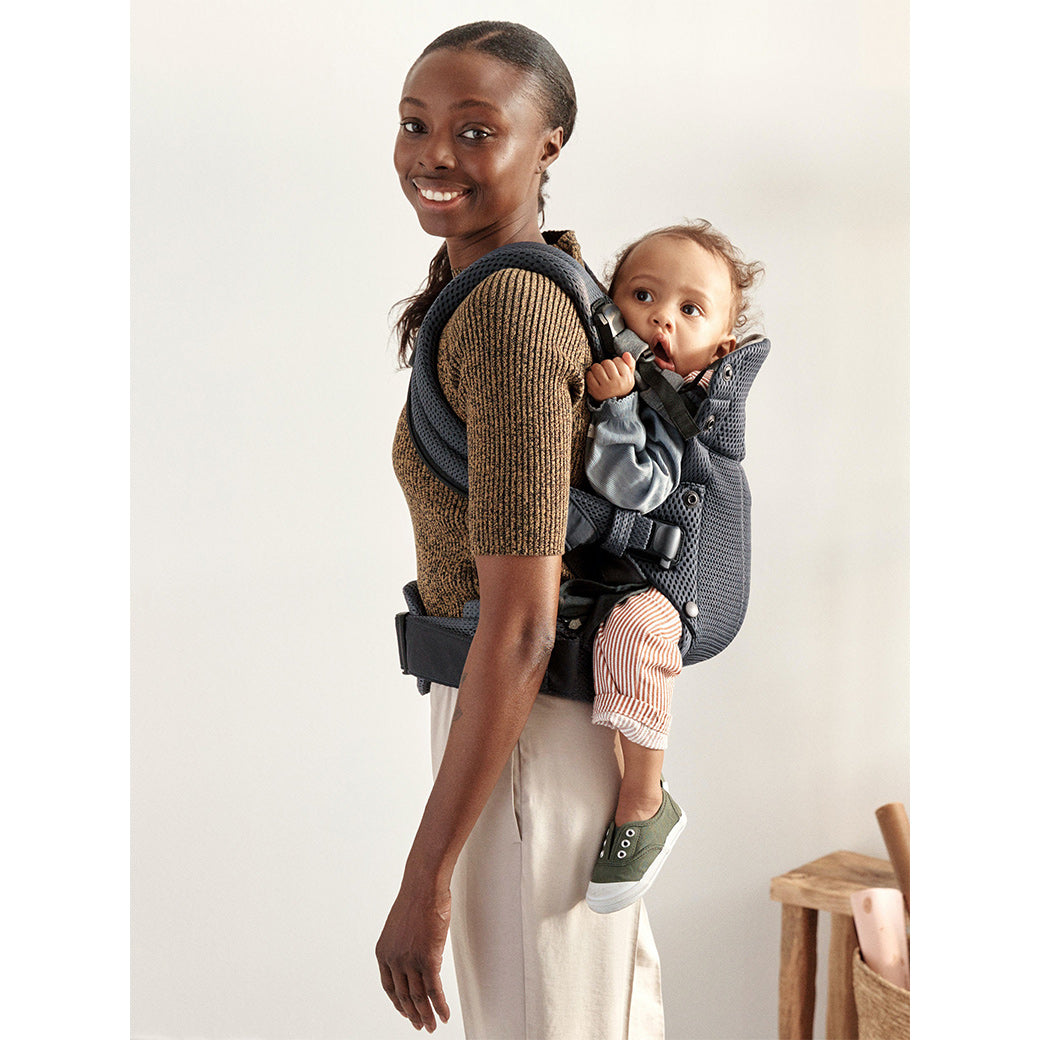 Mom carrying baby in Babybjorn Baby Carrier Harmony on her back in -- Color_Anthracite