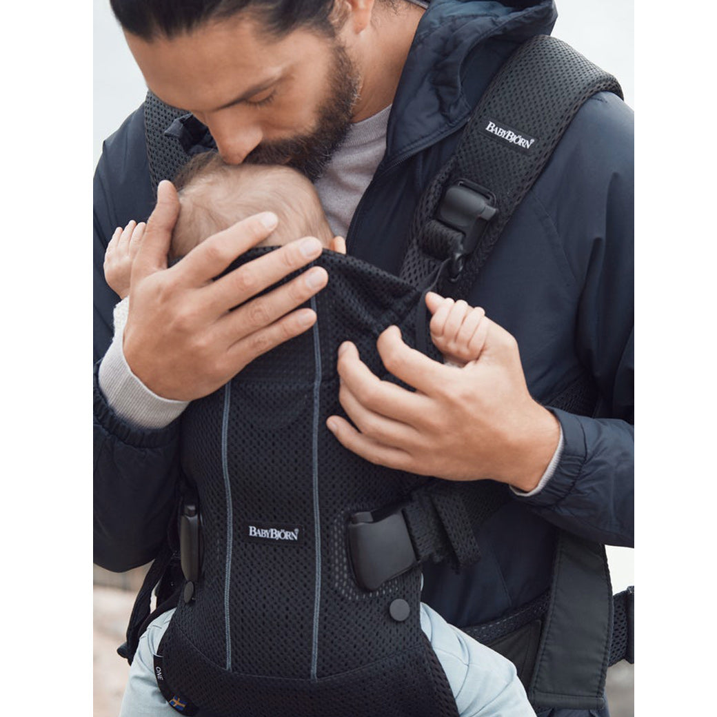 dad kissing baby in BABYBJÖRN Baby Carrier One in -- Color_Black 3D Mesh Air