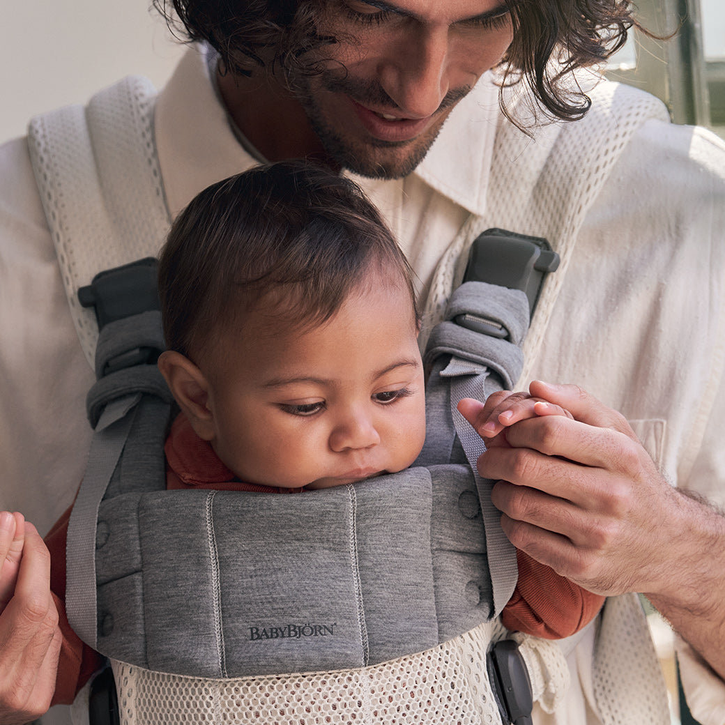 Top view of dad holding baby in Babybjorn Baby Carrier Harmony in -- Color_Cream 3D Mesh