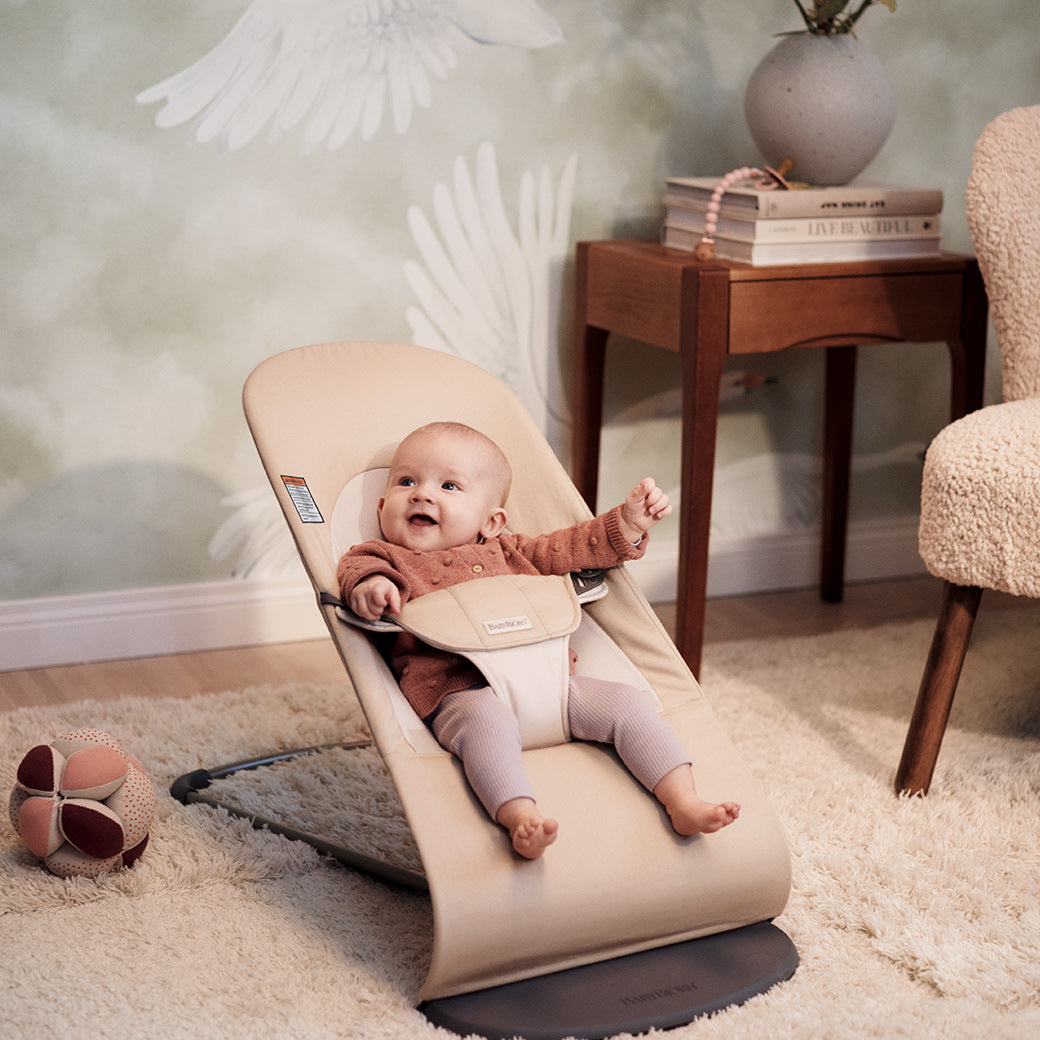 Baby smiling in BABYBJÖRN Bouncer Balance Soft in -- Color_Khaki/Beige Cotton With Light Grey Frame