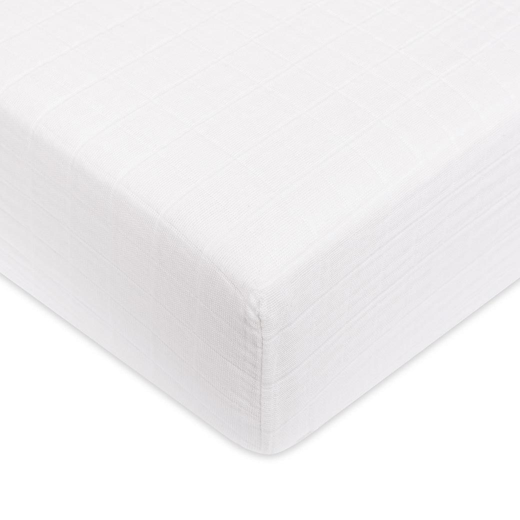 A closeup of the Babyletto's Crib Sheet in GOTS Certified Organic Muslin Cotton corner in -- Color_White