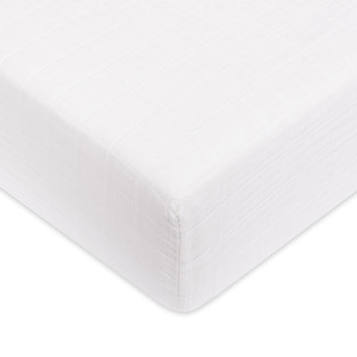 A closeup of the Babyletto's Crib Sheet in GOTS Certified Organic Muslin Cotton corner in -- Color_White