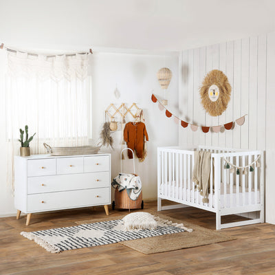 Dadada Austin 3-in-1 Crib in a baby room next to a dresser  in -- Color_White