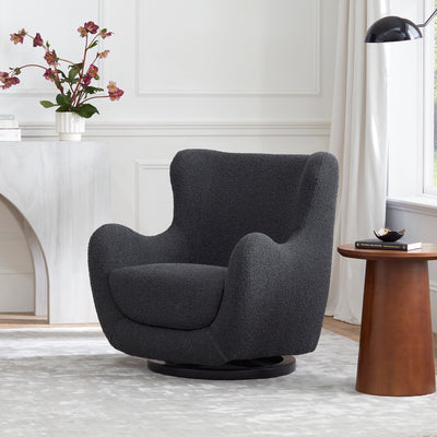 View from a distance of Nursery Works Solstice Swivel Glider in --Color_Black Boucle with Black Wood Base
