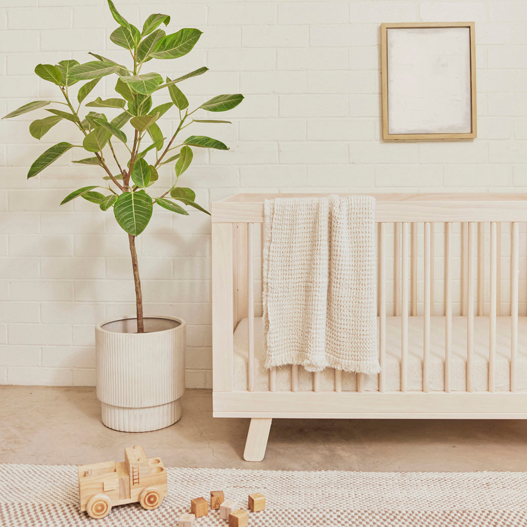 Blanket hanging over the railing of Babyletto Hudson 3-in-1 Crib in -- Color_Washed Natural