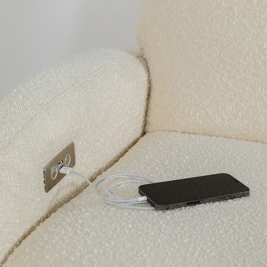 Closeup of phone charging on The Babyletto Nami Glider Recliner in -- Color_Ivory Boucle With Light Wood Base