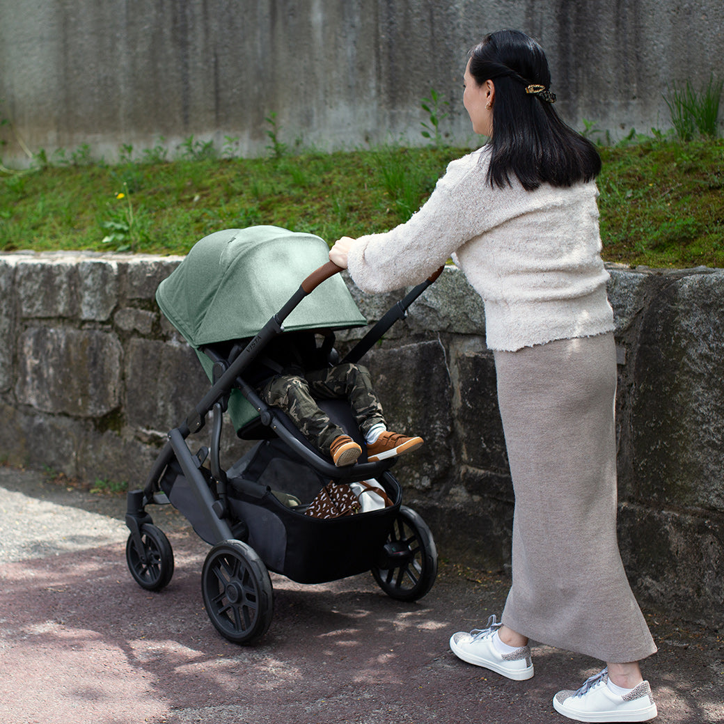 Mother walking child while they nap with the sunshade of their vista v2 stroller all the way down -- Color_Gwen