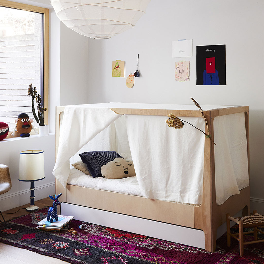 Lifestyle view of Oeuf Perch Nest Bed with mattress in the middle and with curtains on frames