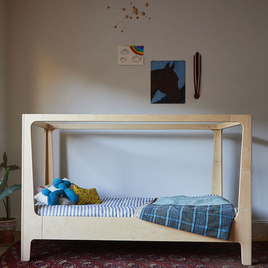 Lifestyle view of Oeuf Perch Nest Bed with a mattress in the middle in a kid`s room