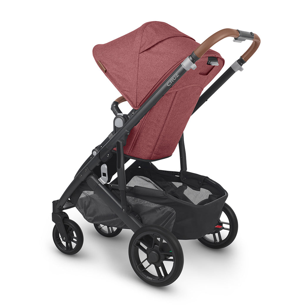 Side view of UPPAbaby CRUZ V2 Stroller with black frame and light red fabric facing left -- Color_Lucy