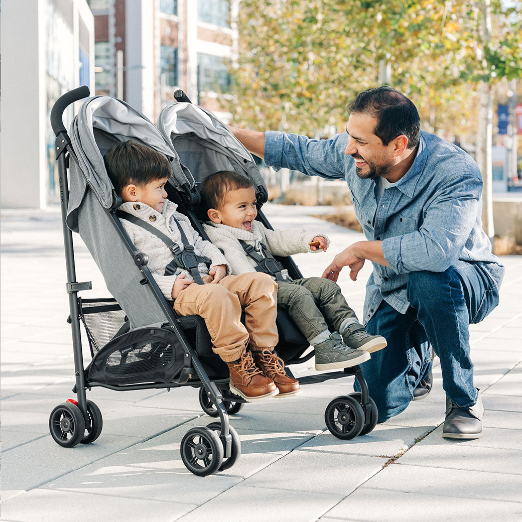 Father crouched next to his kids in the UPPAbaby G Link V2 Stroller in --Color_Greyson