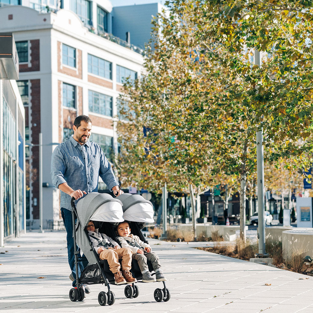 Father pushing his kids in the UPPAbaby G Link V2 Stroller in --Color_Greyson