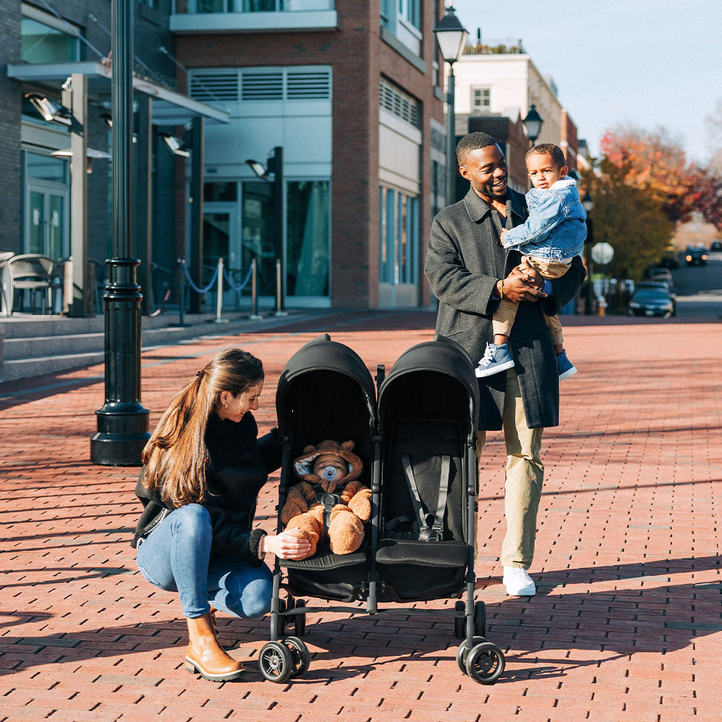 Mother and father on a family walk with kids with the UPPAbaby G Link V2 Stroller in --Color_Jake