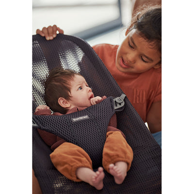 Closeup of sister talking to baby in BABYBJÖRN Bouncer Bliss in -- Color_Anthracite (Slate Gray) Mesh