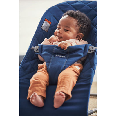 Baby smiling in BABYBJÖRN Bouncer Bliss in -- Color_Midnight Blue Woven, Classic Quilt