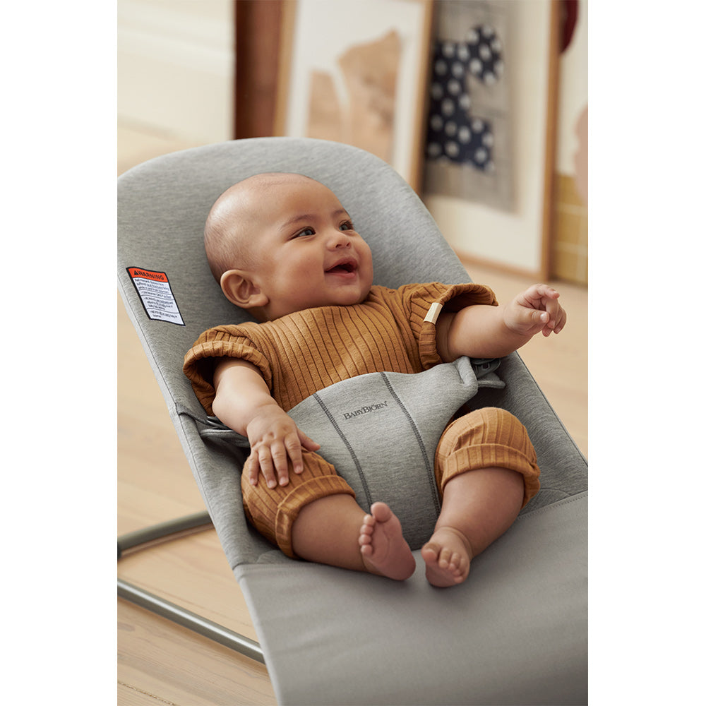 Baby smiling in the BABYBJÖRN Bouncer Bliss in -- Color_Light Gray 3D Jersey