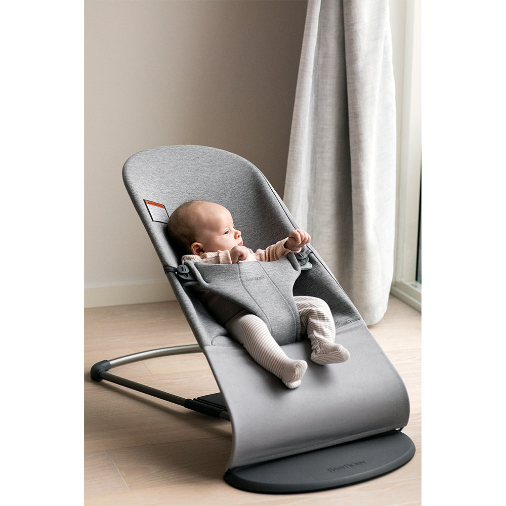 Baby looking out the window sitting in the BABYBJÖRN Bouncer Bliss in -- Color_Light Gray 3D Jersey