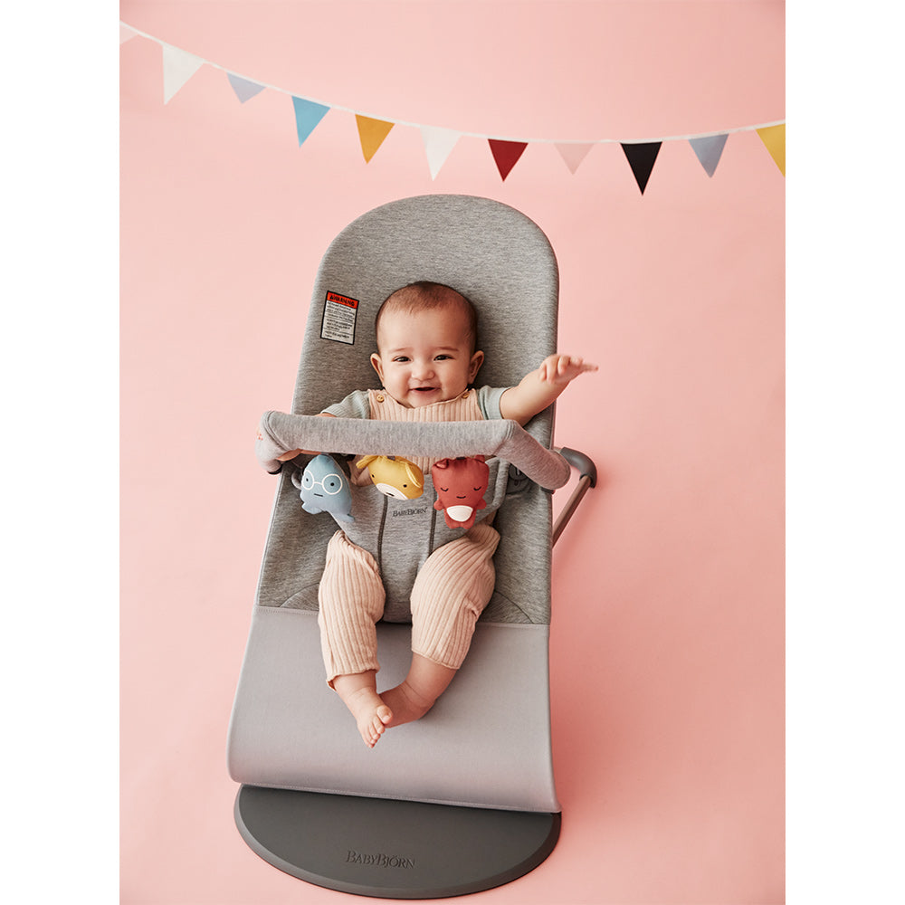 Baby laughing in the BABYBJÖRN Bouncer Bliss with toys attached in -- Color_Light Gray 3D Jersey