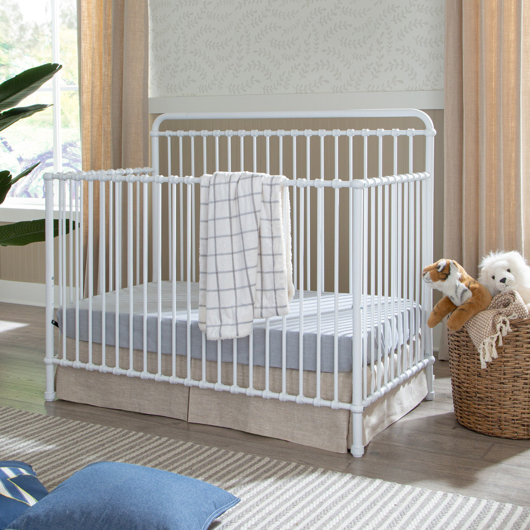 Namesake's Winston 4 in 1 Convertible Crib with a blanket over the rail  in -- Color_Washed White