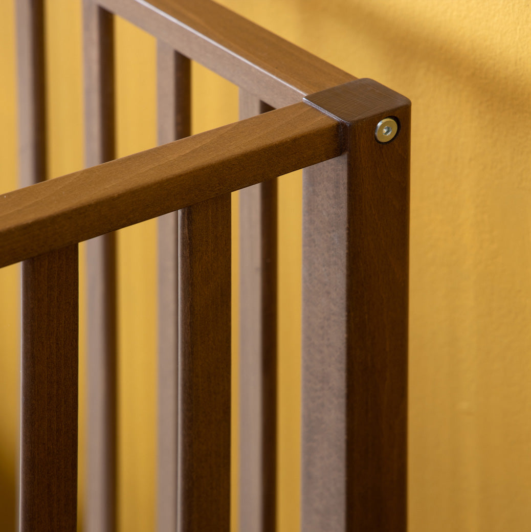 Closeup of the Dadada Lala 3-in-1 Convertible Crib rails connecting  in - Color_Walnut